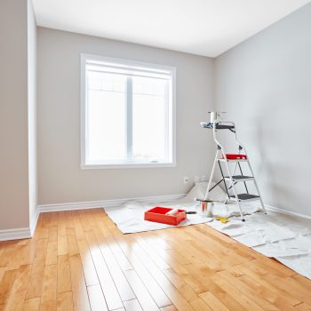 Stepladder and painting tools in modern room. Apartment renovation background