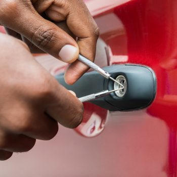 Close-up Of Person Hand Opening Car Door With Lockpicker