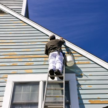 A,Contractor,Or,Painter,On,A,Ladder,Doing,Exterior,Paint